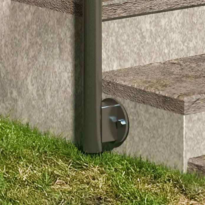 Dolle Geländer-Set PS 511 - Seitenmontage, Edelstahl V2A, Länge: 150 cm - Detailaufnahme einer Treppe mit einem grauen Geländerpfosten, der am steinernen Treppenfuß befestigt ist. Gras wächst um die Basis des Pfostens.