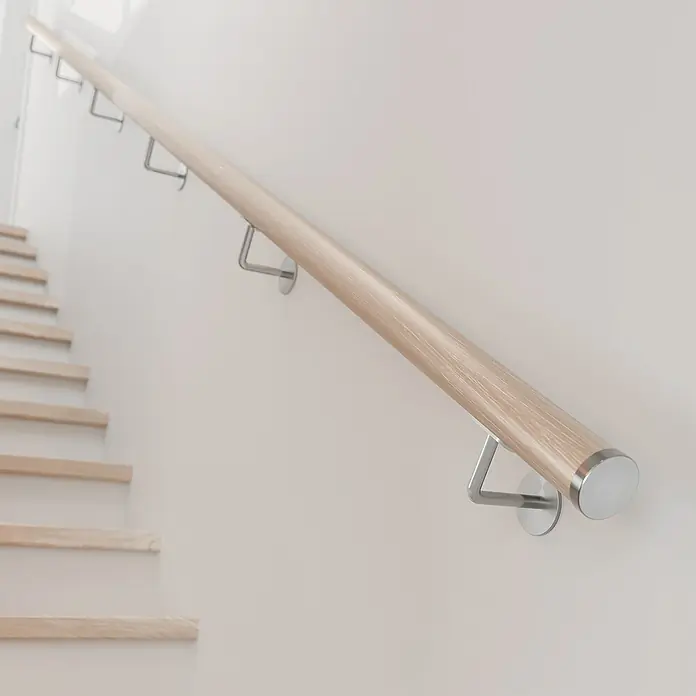 Dolle Handlauf PS 3/50 - Eiche Weiß, Geölt, Rund, Länge: 200 cm - Helle Holztreppe mit einem stilvollen Handlauf aus hellem Holz und silbernen Halterungen an einer weißen Wand.