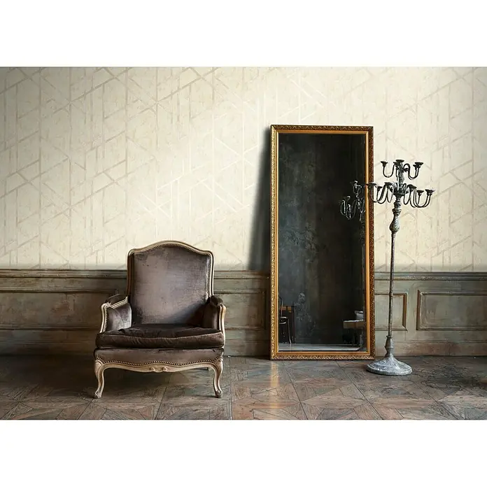 A.S. Création Metropolitan Stories Vliestapete Geometrie - Beige, Grafisch, 10,05 x 0,53 m - Elegantes Interieur mit einem braunen Sessel, einem goldenen Spiegel und einem Kerzenständer vor einer Wand mit geometrischem Muster.