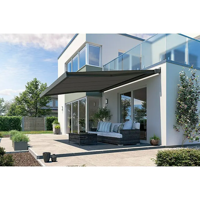 Solid Elements Vollkassettenmarkise Solid-X-Compact 320925 - Dunkelgrau strukturiert, Farbe Gestell: Anthrazitgrau, Breite: 5 m, Ausfall: 2,5 m - Eine moderne Terrasse mit einer grauen Markise, die Schatten spendet, und einem stilvollen Lounge-Bereich mit Couch und Tisch.