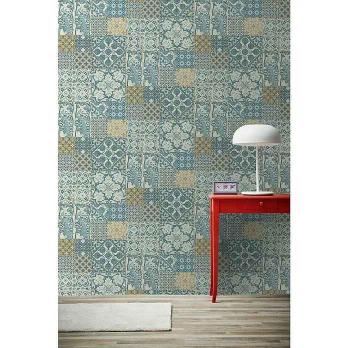 A.S. Création Metropolitan Stories Vliestapete Vintage-Fliese - Türkis/Braun, Fliesenoptik, 10,05 x 0,53 m - Wand mit mehrfarbigem Patchwork-Fliesendesign, roter Tisch mit Lampe und Uhr.