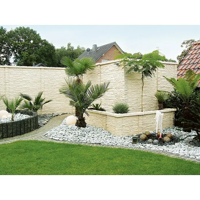 Beckers Betonzaun Zwischenplatte Mediterran Nostalgie - L x B x H: 144 x 30 x 4 cm - Eine malerische Gartenlandschaft mit dekorativen Steinmauern, Zierpflanzen, weißen Kieswegen und einem gepflegten Rasen.