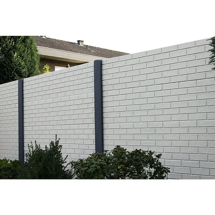 Beckers Betonzaun Zaunelement Standard Stein glatt - 200 x 38,5 cm, Beton, Betongrau - Eine weiße Steinmauer mit grauen Säulen und grünen Büschen im Vordergrund bietet Privatsphäre und dient als attraktiver Gartenzaun.