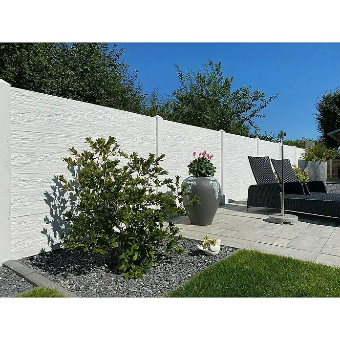 Beckers Betonzaun Zaunelement Standard Nevada Motiv - 200 x 38,5 cm, Beton, Betongrau - Eine elegante Außenanlage mit weißem Sichtschutzzaun, üppiger Bepflanzung und stilvollen Gartenmöbeln unter blauem Himmel.