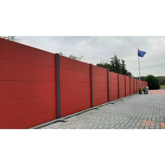 Beckers Betonzaun Zaunelement Standard glatte Platte - 200 x 38,5 cm, Beton, Betongrau - Das Bild zeigt eine rote Lärmschutzwand aus Beton mit grauen Säulen und einem gepflasterten Gehweg davor. Im Hintergrund weht die EU Flagge.