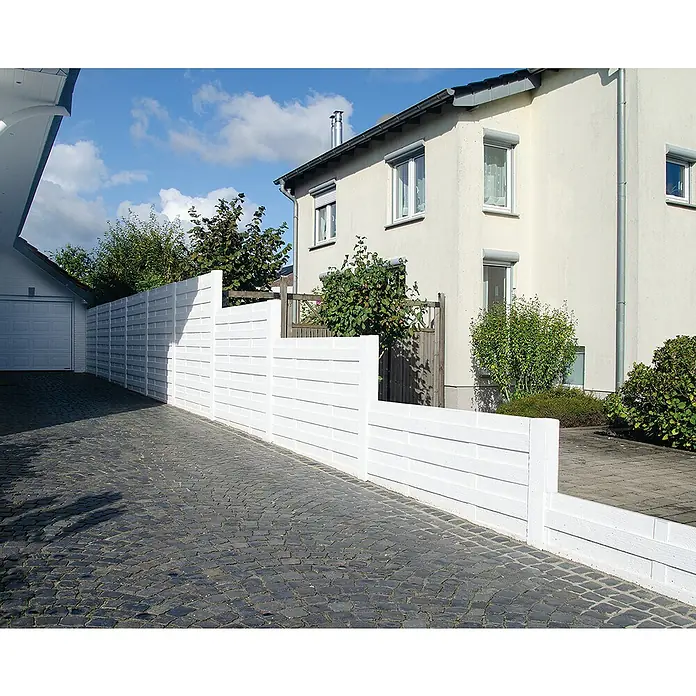 Beckers Betonzaun Zaunelement Standard Elegant Motiv - 200 x 38,5 cm, Beton, Betongrau - Helle Holzimitat-Zaunpaneele vor einem zweistöckigen Wohnhaus. Das moderne Design bietet Privatsphäre und fügt sich nahtlos in die Umgebung ein.