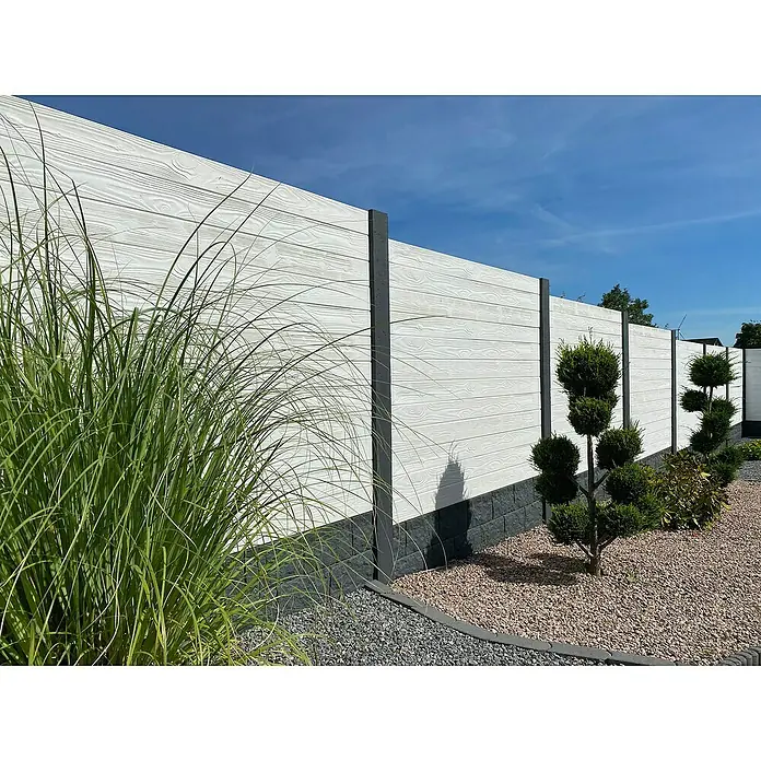 Beckers Betonzaun Zaunelement Standard Prestige Motiv - 200 x 38,5 cm, Beton, Betongrau - Nahaufnahme eines modernen weißen Gartenzauns mit grauen Pfosten und dekorativen Pflanzen. Der Zaun bietet Privatsphäre und ästhetischen Reiz.