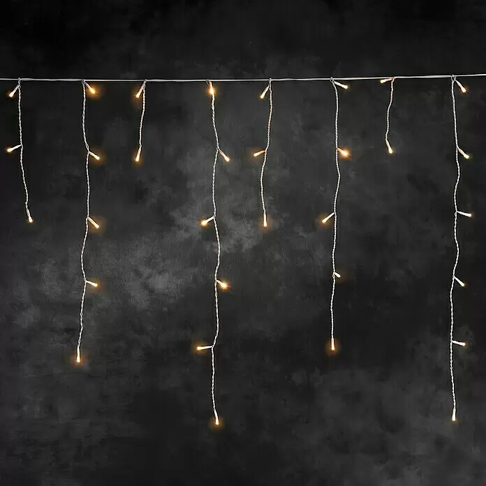 Konstsmide LED-Lichtervorhang Eisregen - Außen, 0,75 m, Bernstein, 336 Stk., Netzbetrieben - Eiszapfen-Lichterkette mit warmweißen LEDs und weißen Kabeln vor dunklem Hintergrund.