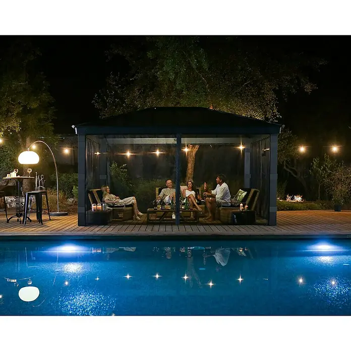 Palram – Canopia Cortina mosquitera para cenador Dallas - An x Al: 500 x 360 cm, Gris - Un grupo de amigos se relaja en una elegante glorieta con iluminación junto a la piscina. La glorieta ofrece sombra y refugio para disfrutar al aire libre.
