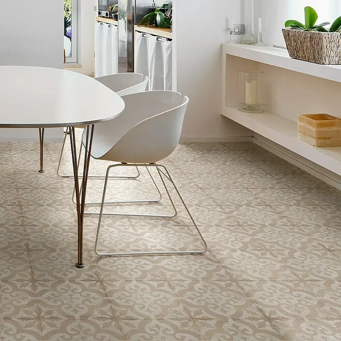 Feinsteinzeugfliese Triana Flor - 24,8 x 24,8 cm, Beige, Matt - Ein Bild von dekorierten Bodenfliesen in einem Essbereich mit einem weißen Tisch und Stühlen, die ein stilvolles und einladendes Ambiente schaffen.