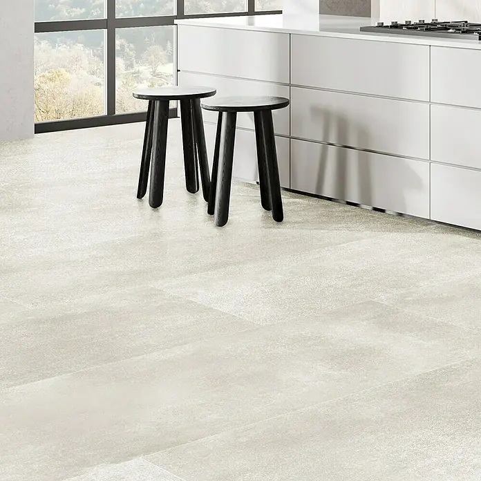 Feinsteinzeugfliese Rimini - 60 x 120 cm, Bianco, Matt - Eine Nahaufnahme von modernen, dunklen Holz-Barhockern vor einer weißen Kücheninsel, die ein elegantes und minimalistisches Küchendesign hervorhebt.