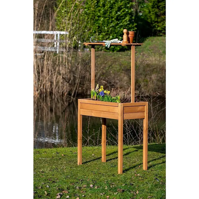 Dobar Hochbeet - 80 x 40 x 145 cm, Holz, Braun - Ein hölzerner Pflanztisch mit Blumen, Gartengeräten und Töpfen steht im Garten, ideal für Hobbygärtner.