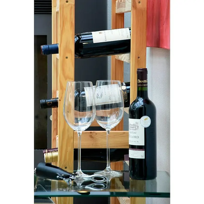 Dobar Weinregal - L x B x H: 72 x 25 x 117,5 cm, Anzahl Flaschen: 56 Stk., Natur - Das Bild zeigt eine Flasche Chateau Meylord Bordeaux 2010, zwei leere Weingläser und einen Korkenzieher auf einem Glastisch vor einem Weinregal.