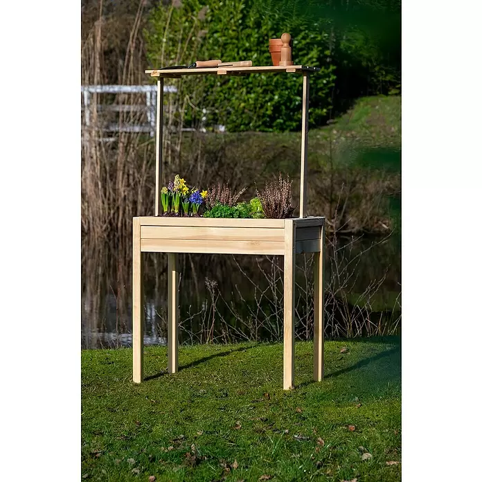 Dobar Hochbeet - 80 x 40 x 145 cm, Holz, Natur - Erhöhtes Hochbeet aus hellem Holz mit Ablage für Gartengeräte und Töpfe, bepflanzt mit Frühlingsblumen und Kräutern, draußen stehend.