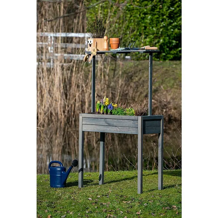 Dobar Hochbeet - 80 x 40 x 145 cm, Holz, Anthrazit - Ein grauer Pflanztisch mit Ablagefläche, bepflanzt mit bunten Blumen und Kräutern, sowie einer blauen Gießkanne daneben.