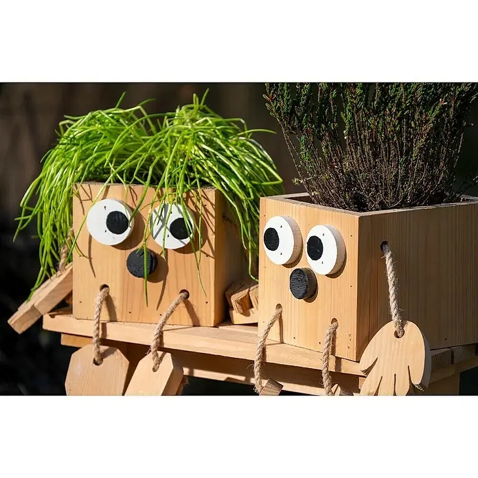 Dobar Pflanztopf Kräuterschwestern Laura & Lisa - Holz, Braun - Zwei lustige, hölzerne Pflanzgefäße mit großen Augen und Pflanzenfrisuren stehen auf einem Holzregal und bringen Freude in den Garten.