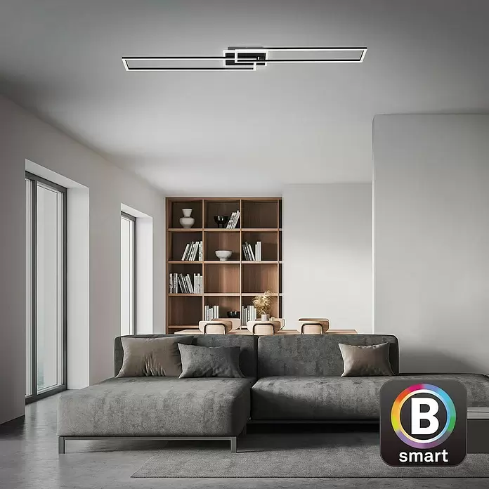 Brilo LED-Wand- & Deckenleuchte Frame S - 34 W, L x B x H: 110 x 24,8 x 7,8 cm, Schwarz, Warmweiß - Moderne schwarze LED-Deckenleuchte mit geometrischem Design, beleuchtet ein modernes Wohnzimmer.