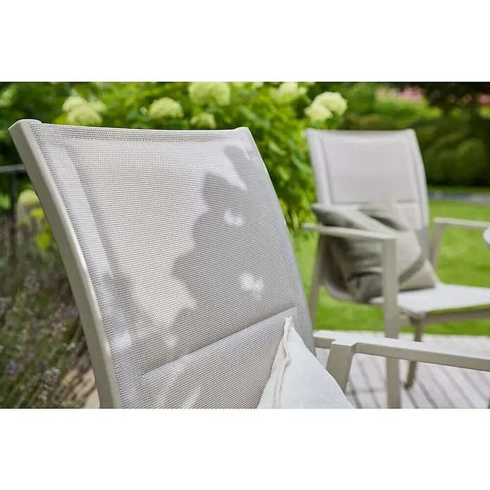 Sunfun Maja Stapelsessel - Aluminium, Stapelbar, Light-Greige, B x T x H: 56,5 x 66 x 91 cm - Nahaufnahme von zwei modernen Gartenstühlen mit grauen Bezügen und Kissen, die im Freien auf einer Terrasse stehen.