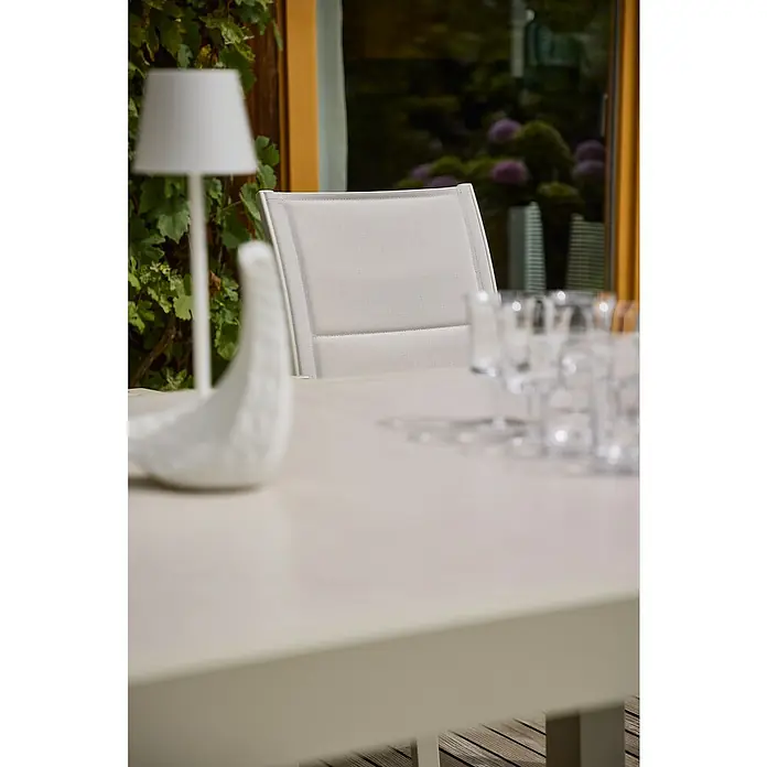 Sunfun Maja Stapelsessel - Aluminium, Stapelbar, Light-Greige, B x T x H: 56,5 x 66 x 91 cm - Nahaufnahme eines weißen Gartentisches mit Stuhl, einer Dekofigur und Gläsern, die eine elegante und einladende Atmosphäre schaffen.