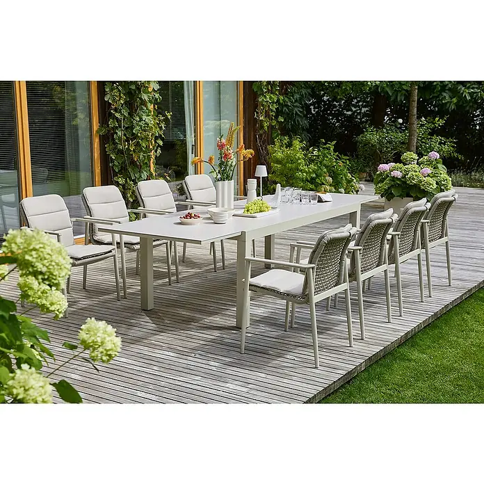 Sunfun Solo Rope Gartensessel - Stapelbar, Light-Greige, B x T x H: 67 x 63 x 85 cm - Ein langer Esstisch mit bequemen Stühlen auf einer Holzterrasse. Der Tisch ist mit Speisen und Getränken gedeckt.