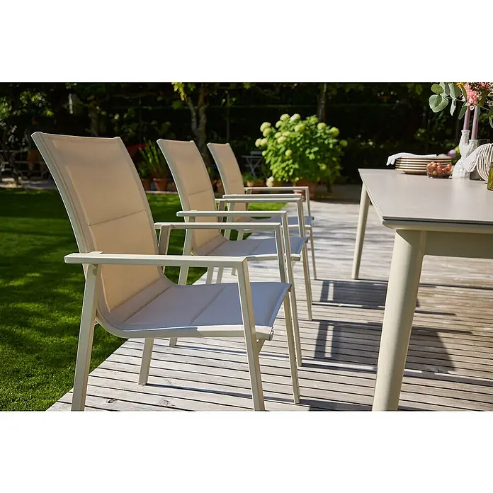 Sunfun Maja Stapelsessel - Aluminium, Stapelbar, Light-Greige, B x T x H: 56,5 x 66 x 91 cm - Eine Reihe von hellen Gartenstühlen aus Metall und Textil stehen auf einer Holzterrasse neben einem passenden Tisch.