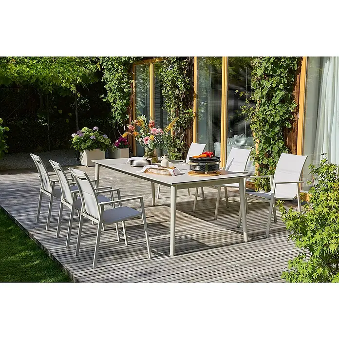 Sunfun Maja Stapelsessel - Aluminium, Stapelbar, Light-Greige, B x T x H: 56,5 x 66 x 91 cm - Ein schöner Esstisch mit weißen Stühlen auf einer Terrasse, perfekt für Mahlzeiten im Freien.