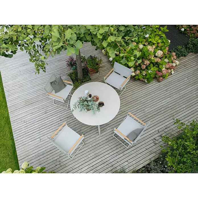 Sunfun Solo Gartentisch rund - Ø x H: 120 x 74 cm, Aluminium, Sintered Stone, Light-Greige - Gartentisch mit vier Stühlen auf einer Holzterrasse. Der Tisch ist mit Dekorationen versehen.