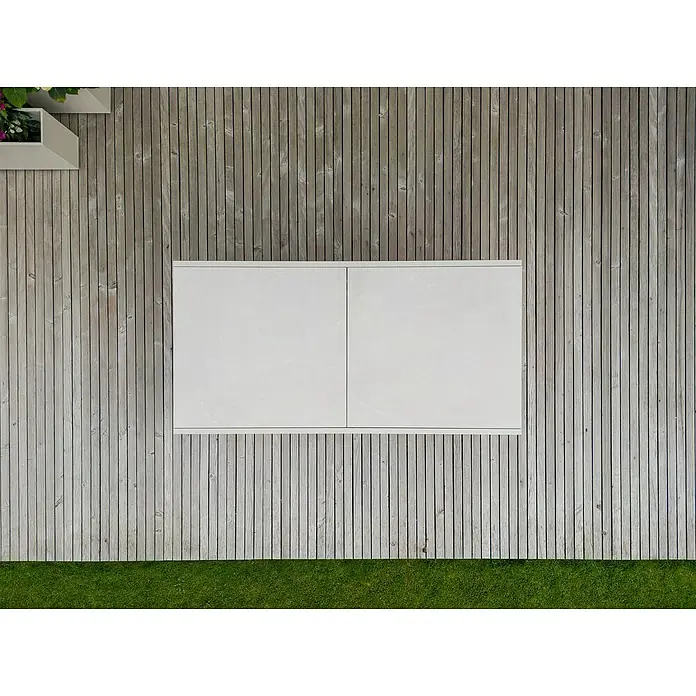 Sunfun Maja Gartentisch Stone - L x B x H: 300 x 100 x 74 cm, Aluminium, Sintered Stone, Ausziehbar, Light-Greige - Draufsicht auf einen weißen Tisch auf einer Terrasse mit Holzdielen und Rasen. Ein minimalistisches Design für den Außenbereich.
