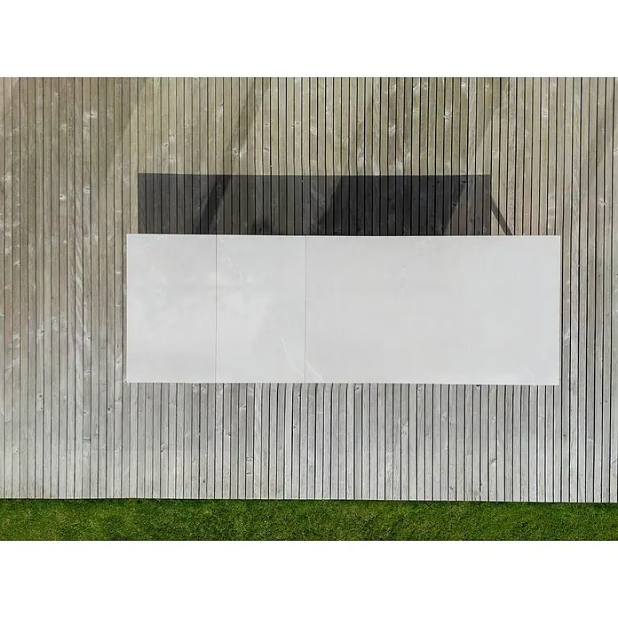Sunfun Solo Garten-Tischplatte Erweiterung - L x B: 60 x 100 cm, Aluminium, Sintered Stone, Light-Greige - Draufsicht auf einen Gartentisch mit weißer Tischplatte, umgeben von einer Holzterrasse und einem Rasen. Ideal für den Außenbereich.