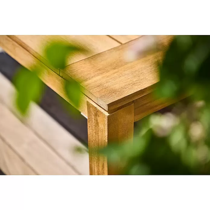 Sunfun Laura Gartentisch - L x B x H: 220 x 100 x 76 cm, Akazie, Rechteckig, Naturbraun - Ecke eines hellbraunen Holztisches, die Maserung und stabile Verbindungen zeigt.