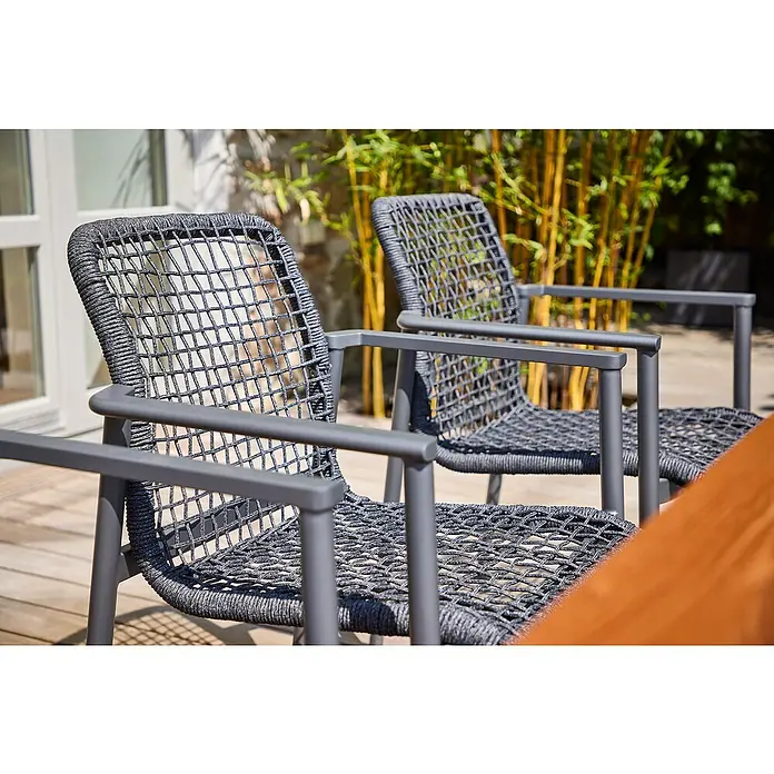 Sunfun Solo Rope Gartensessel - Stapelbar, Night-Grey, B x T x H: 67 x 63 x 85 cm - Zwei moderne Rattansessel mit grauem Gestell stehen auf einer Terrasse. Die Sessel laden zum Verweilen im Freien ein.