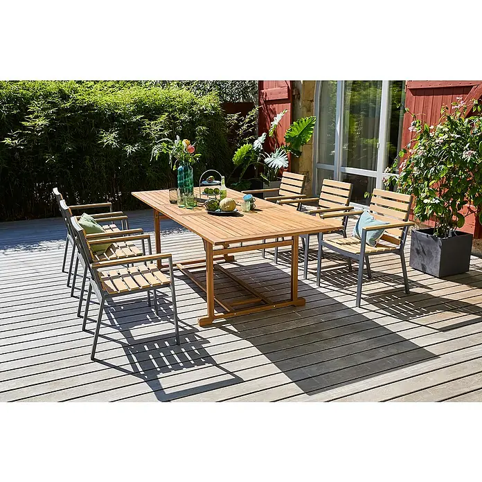 Sunfun Gartenmöbel-Set Diana/Carina - 7 -tlg., Anthrazit/Akazie, Ausziehbar - Holzgartentisch mit passenden Stühlen auf einer Terrasse, umgeben von üppigem Grün. Perfekt für Mahlzeiten im Freien.
