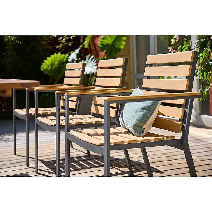 Sunfun Carina Gartenstuhl - Akazie, Stapelbar, Natur, B x T x H: 57,5 x 61 x 86 cm - Drei moderne Gartenstühle mit Armlehnen aus Holz und Metall auf einer Terrasse, einer davon mit einem Kissen dekoriert.