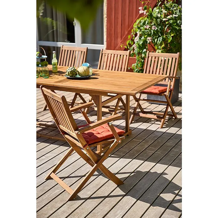 Sunfun Gartenmöbel-Set Diana - 7 -tlg., Akazie, Ausziehbar - Einladender Außenbereich mit einem Holztisch und passenden Stühlen mit roten Sitzkissen. Perfekt für gemütliche Stunden im Garten.