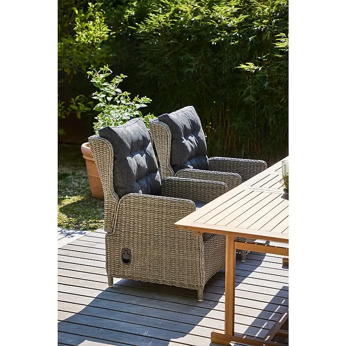 Sunfun Gartenmöbel-Set Diana/Pauline - 7 -tlg., Grau/Akazie, Ausziehbar, Tisch (L x B x H): 180-230 x 100 x 75 cm, Stuhl (T x B x H): 81 x 64 x 101 cm - Nahaufnahme von zwei grauen Rattansesseln mit grauen Kissen auf einer Holzterrasse im Freien mit Tisch.
