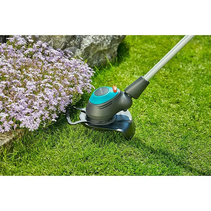 Gardena Elektro-Rasentrimmer EasyCut 450/25 - 450 W, Schnittbreite Faden: 25 cm - Akku-Rasentrimmer von Gardena im Einsatz, umgeben von Blumen. Ideal für präzise Rasenpflege und Kantenschnitte.