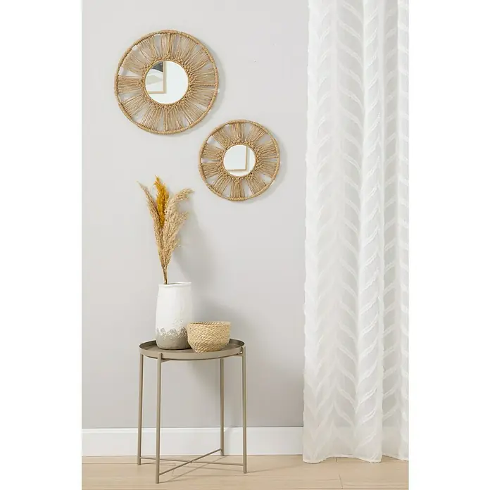 Espejo de pared Serena - 2 pzs., Diámetro: 45 cm, Natural - Primer plano de dos espejos de pared redondos con marcos decorativos de paja, una mesa auxiliar, un jarrón y una cortina.