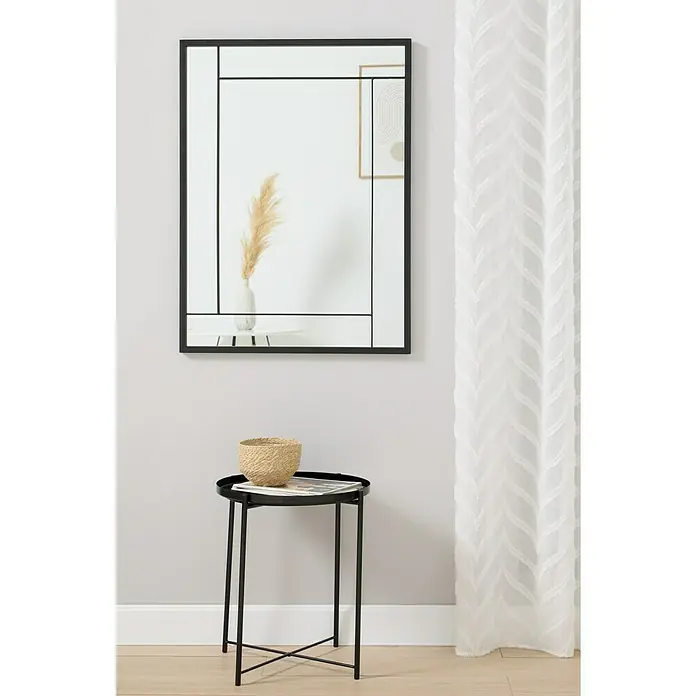 Espejo de pared Sono - 70 x 95 cm, Negro - Primer plano de un espejo de pared cuadrado con marco negro, montado sobre una pequeña mesa con un cuenco decorativo.