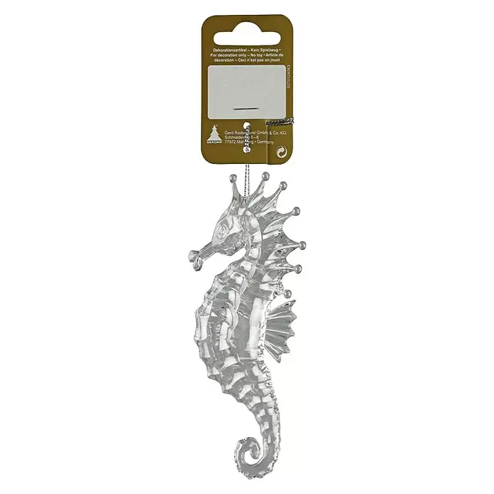 Christbaumschmuck Seepferdchen - Silber, Kunststoff, 1 Stk. - Transparenter, kristallartiger Seepferdchen-Anhänger an einem braunen Etikett.