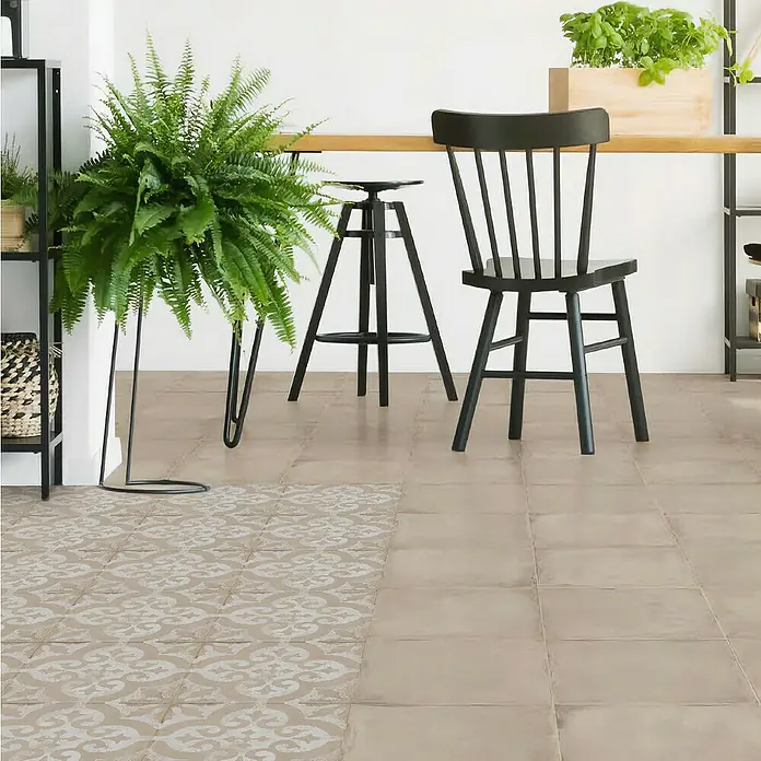 Feinsteinzeugfliese Triana - 24,8 x 24,8 cm, Beige, Matt - Einrichtungsszene mit Stuhl, Barhocker und Zimmerpflanze auf einem stilvollen, gefliesten Boden.