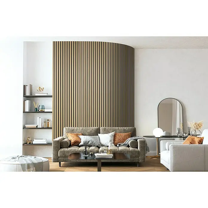 FibroTech Akustikpaneel Quanti - Light Oak, 2.440 x 520 x 18 mm - Modernes Wohnzimmer mit grauem Sofa, Bücherregal und einer Akustikpaneel-Wand, die für eine angenehme Atmosphäre sorgt und gleichzeitig Schall absorbiert.