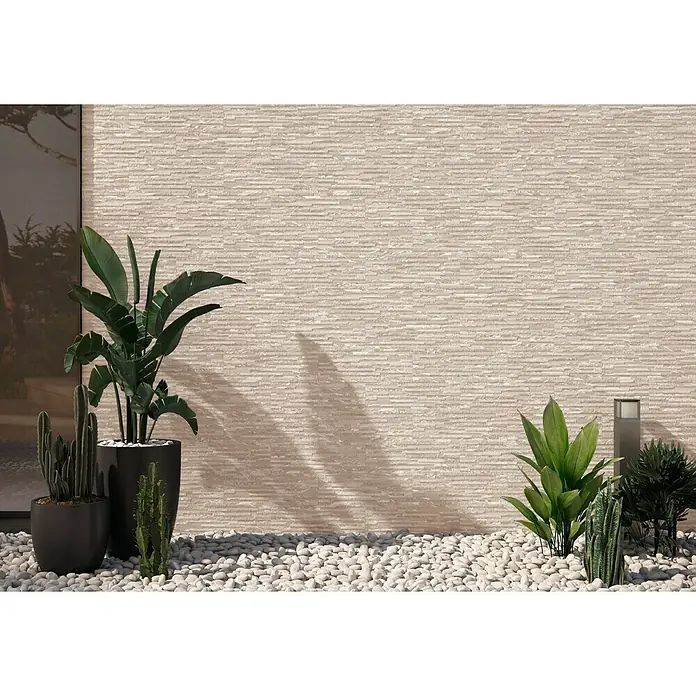 Revestimiento de pared Maule - 17 x 52 cm, Beige, Mate - Primer plano de un elegante diseño de pared exterior con textura de piedra y vegetación.