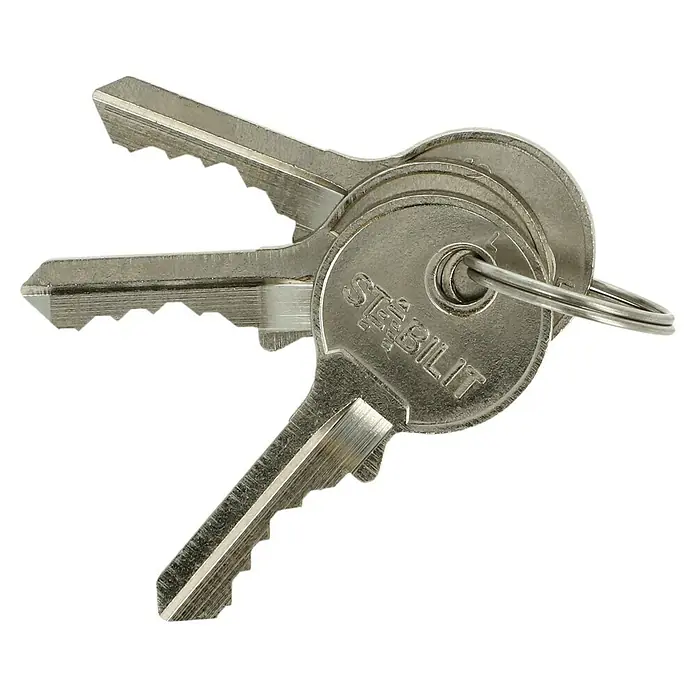 Stabilit Vorhängeschloss A40-63 - 40 x 102 mm, 1 Stk., Aluminium - Nahaufnahme von drei silbernen Stabilit-Schlüsseln an einem Schlüsselring, die auf einem schwarzen Hintergrund liegen.