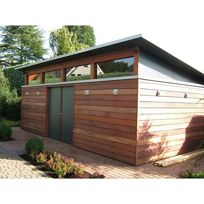 Terrassendiele - 244 x 14,5 x 2,1 cm, Braun - Dieses Bild zeigt einen modernen Geräteschuppen mit Holzverkleidung, Fenstern und einem Flachdach, umgeben von grüner Vegetation auf einem gepflasterten Weg.