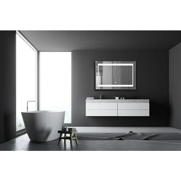 DSK Lichtspiegel Silver Futura - 100 x 70 cm - Elegantes Badezimmer mit einem modernen, beleuchteten Spiegel über einem schwebenden Waschtisch und einer freistehenden Badewanne vor einem großen Fenster.