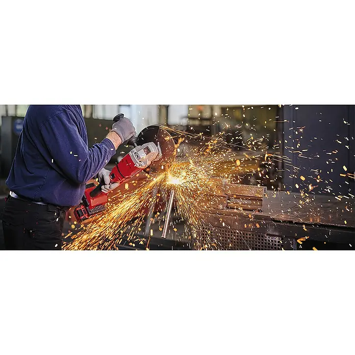 Einhell Professional PXC 18V Amoladora angular de batería Axxio 36/230 Q - 18 V, Sin batería, Diámetro disco: 230 mm - Un trabajador usa una amoladora angular para cortar metal, con chispas. La amoladora roja destaca.