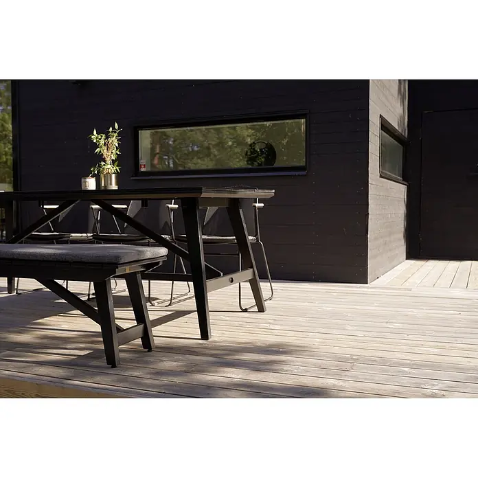 SENSUM Gartenbank - B x T x H: 192 x 38 x 43 cm, Eukalyptus, Schwarz - Schwarze Gartengarnitur mit Tisch, Bank und Stühlen auf einer Holzterrasse vor einem modernen schwarzen Haus. Die Möbel sind stilvoll und einladend.