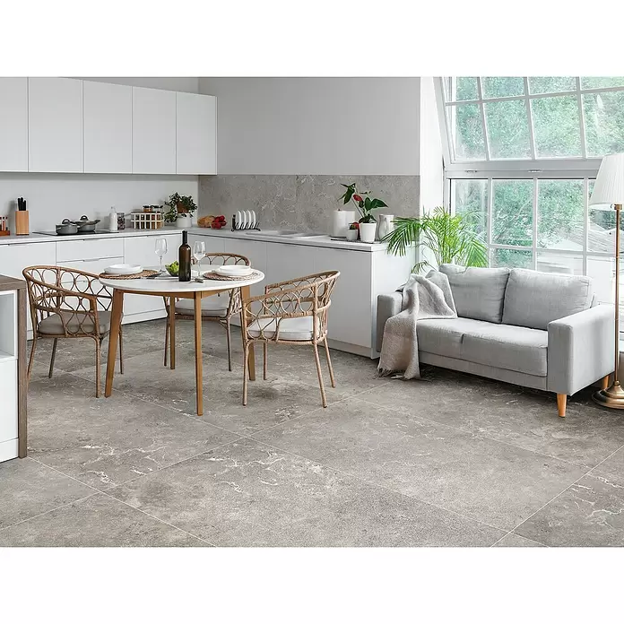 Feinsteinzeugfliese Tivoli Stone - 60 x 119,5 cm, Smoke, Glänzend - Große graue Bodenfliesen mit subtiler weißer Maserung bedecken einen modernen Küchen- und Wohnbereich.