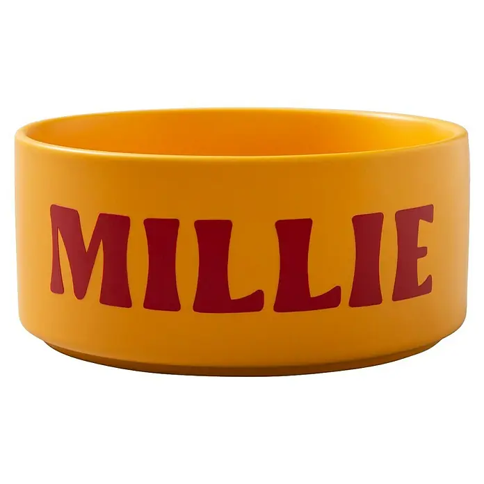 Cricut Vinylfolie Material Starter Bundle - 9 -tlg., Bunt - Gelbe Keramik-Hundenapf mit dem Namen "Millie" in roter Schrift, ideal für Futter oder Wasser.