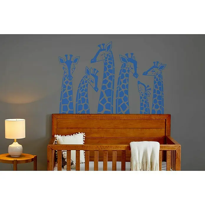 Cricut Vinylfolie Material Starter Bundle - 9 -tlg., Bunt - Eine Nahaufnahme eines Kinderzimmers mit einer Wanddekoration aus Giraffen und einem Holzbett.